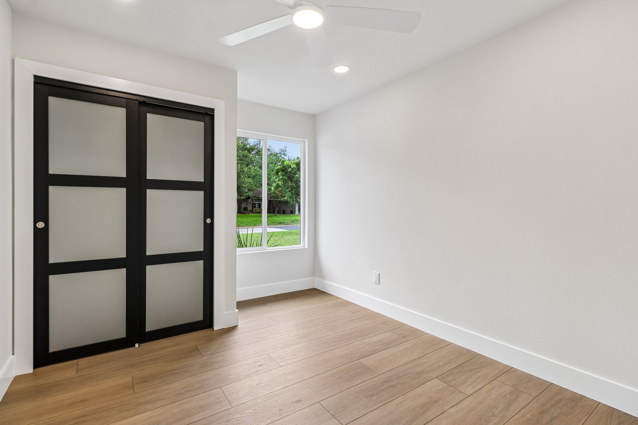 11809 Charing Cross Road Austin, TX 78759 - Photo 19 of 34 Bright and airy, this room features beautiful wood flooring and a modern ceiling fan for comfort.