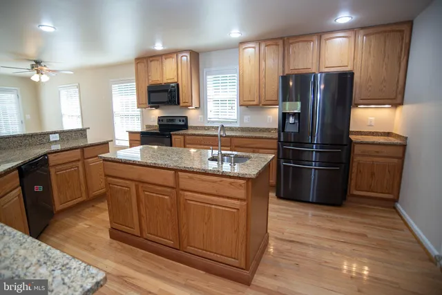 a kitchen with stainless steel appliances granite countertop a refrigerator a sink and dishwasher