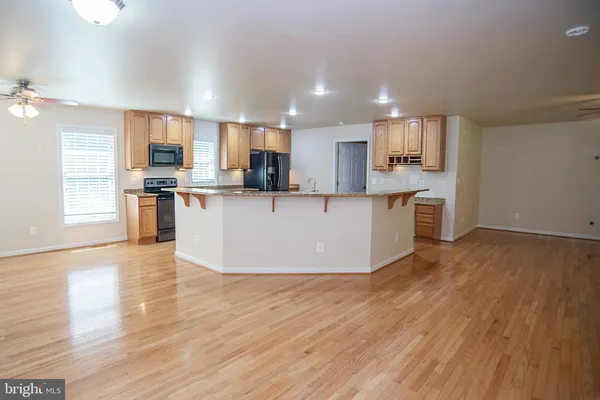 a view of kitchen with cabinets microwave and stove