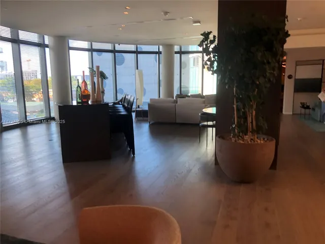 a living room with furniture wooden floor and a floor to ceiling window