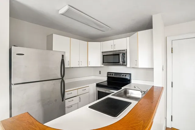 a kitchen with stainless steel appliances a refrigerator stove and microwave