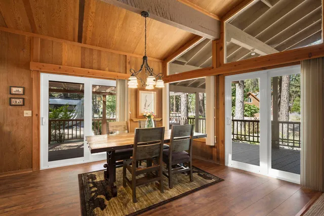 a view of a dining room with furniture wooden floor and floor to ceiling window