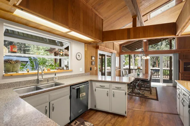 a large kitchen with stainless steel appliances granite countertop a sink and cabinets