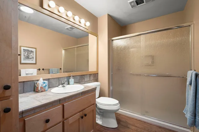 a bathroom with a granite countertop sink toilet and shower