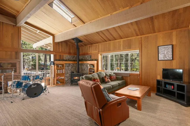a living room with furniture a rug and a floor to ceiling window