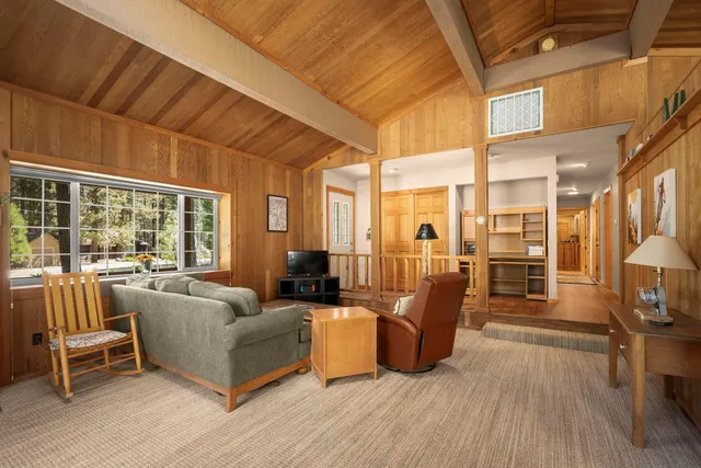 a living room with furniture a wooden floor and next to a window