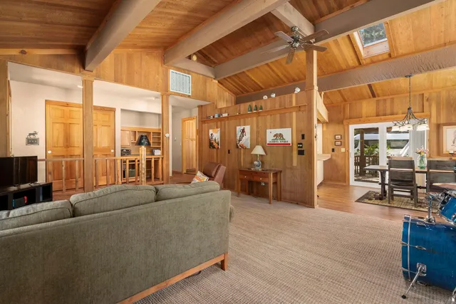 a living room with furniture a wooden floor and next to a window