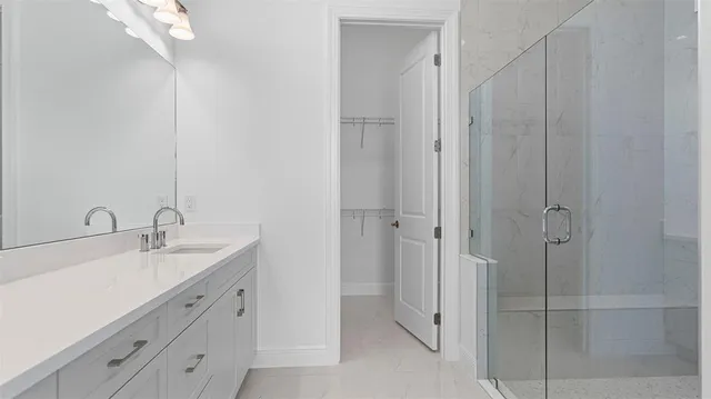 a spacious bathroom with a double vanity sink a mirror and shower