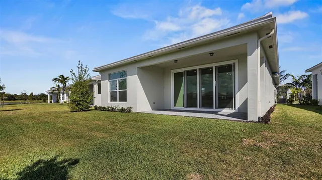 a view of a big house with a big yard and large trees