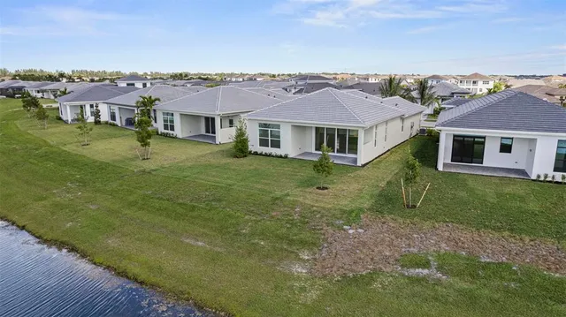 an aerial view of residential houses with outdoor space and trees