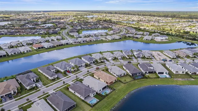 an aerial view of residential houses with outdoor space and ocean view