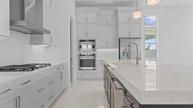 a kitchen with white cabinets and appliances