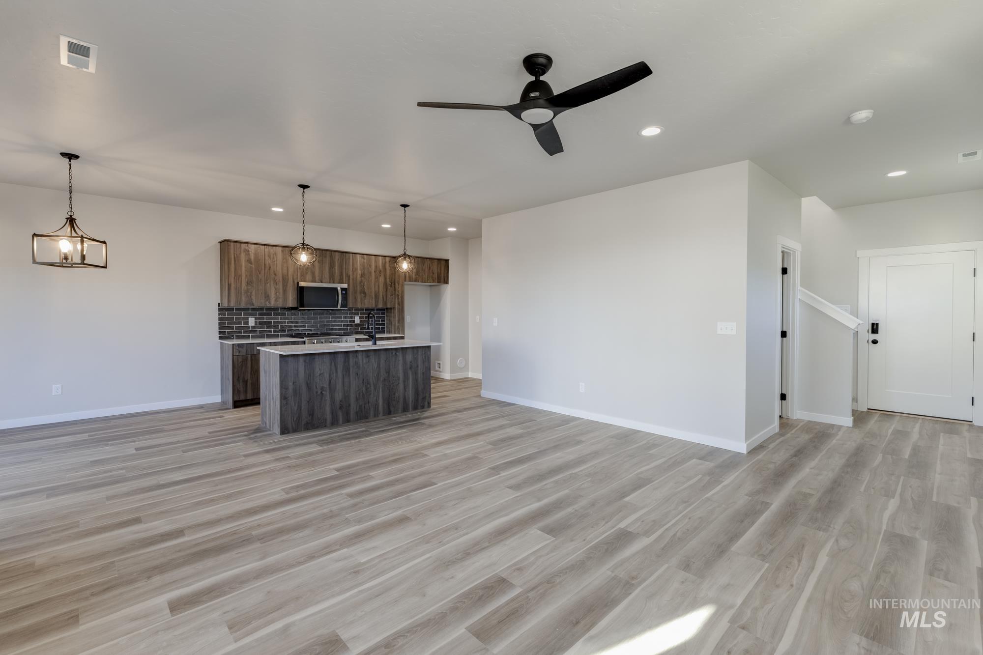 10574 West Teratai Street Star, ID 83669 - Photo 22 of 23 Kitchen featuring open floor plan, a center island with sink, tasteful backsplash, decorative light fixtures, and recessed lighting