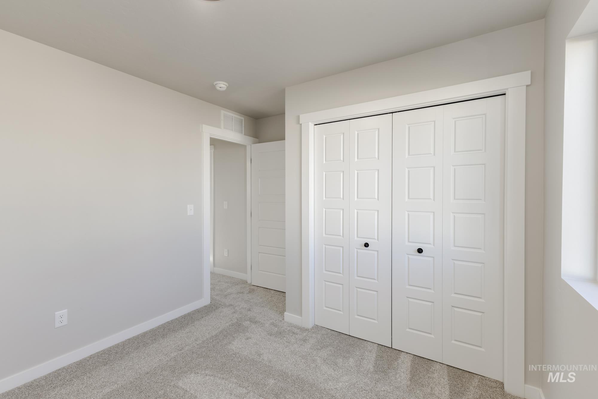 10574 West Teratai Street Star, ID 83669 - Photo 16 of 23 Unfurnished bedroom with light colored carpet and a closet