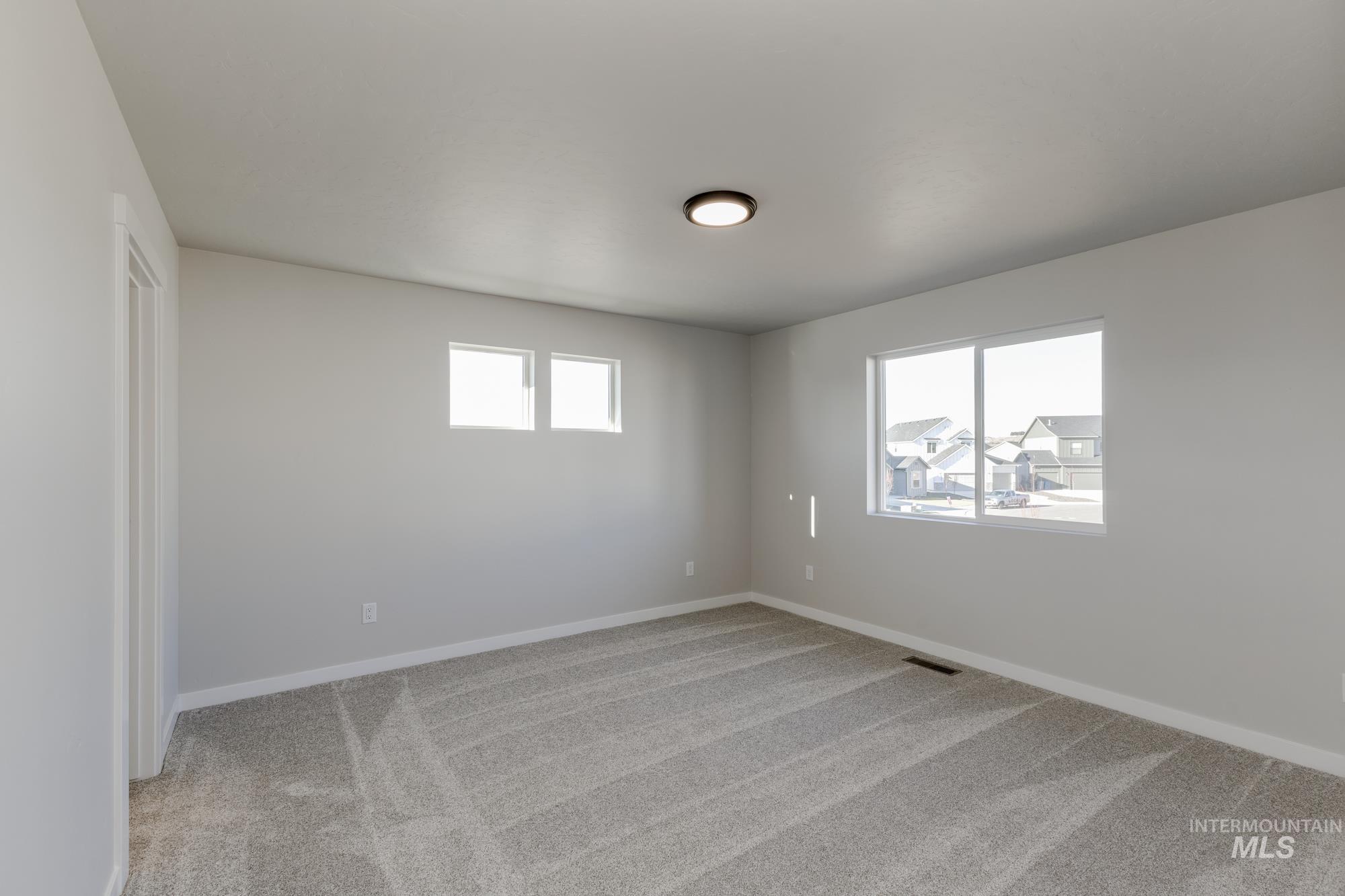 10574 West Teratai Street Star, ID 83669 - Photo 18 of 23 Empty room with light colored carpet and baseboards