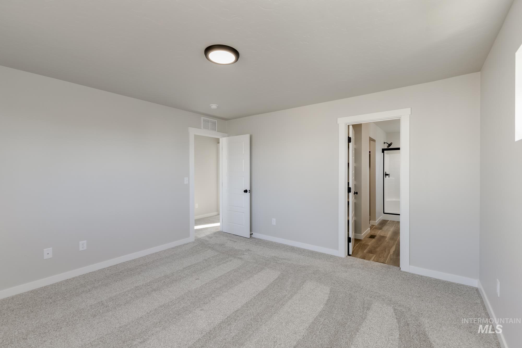 10574 West Teratai Street Star, ID 83669 - Photo 19 of 23 Unfurnished bedroom featuring light colored carpet and ensuite bathroom
