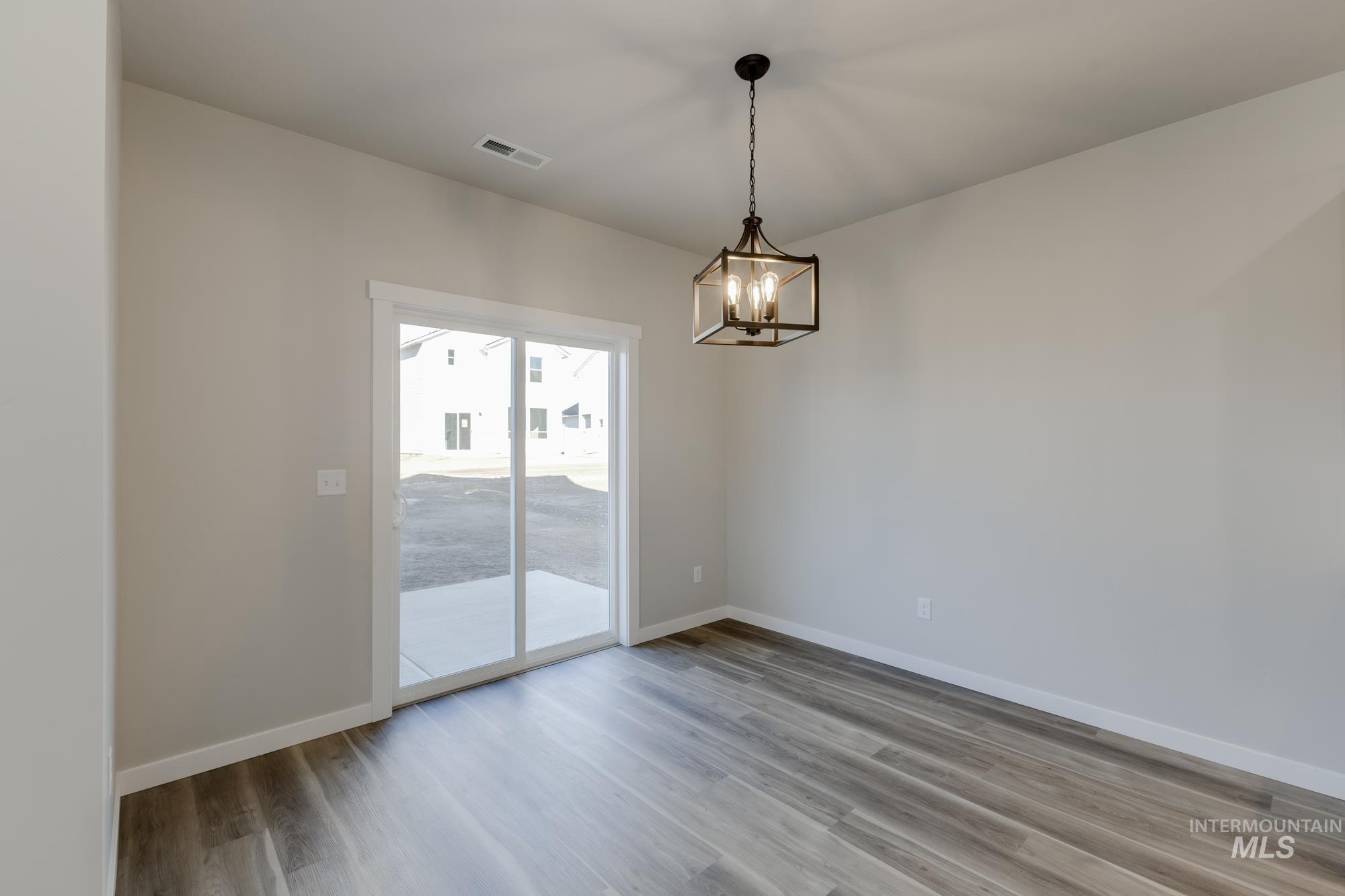 10574 West Teratai Street Star, ID 83669 - Photo 8 of 23 Unfurnished dining area featuring light wood-type flooring and a chandelier