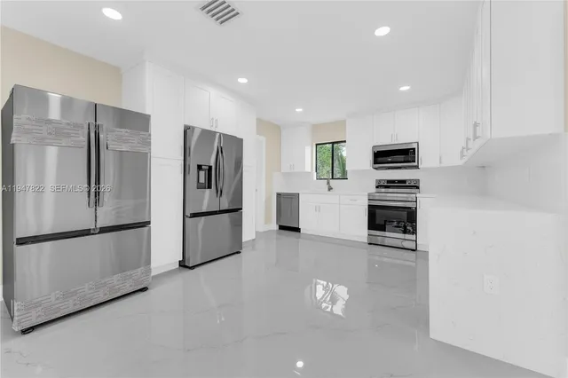 a kitchen with stainless steel appliances a refrigerator stove microwave and sink