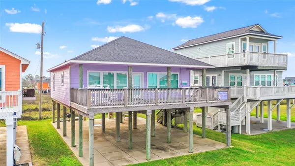 a porch with a table chairs and a yard