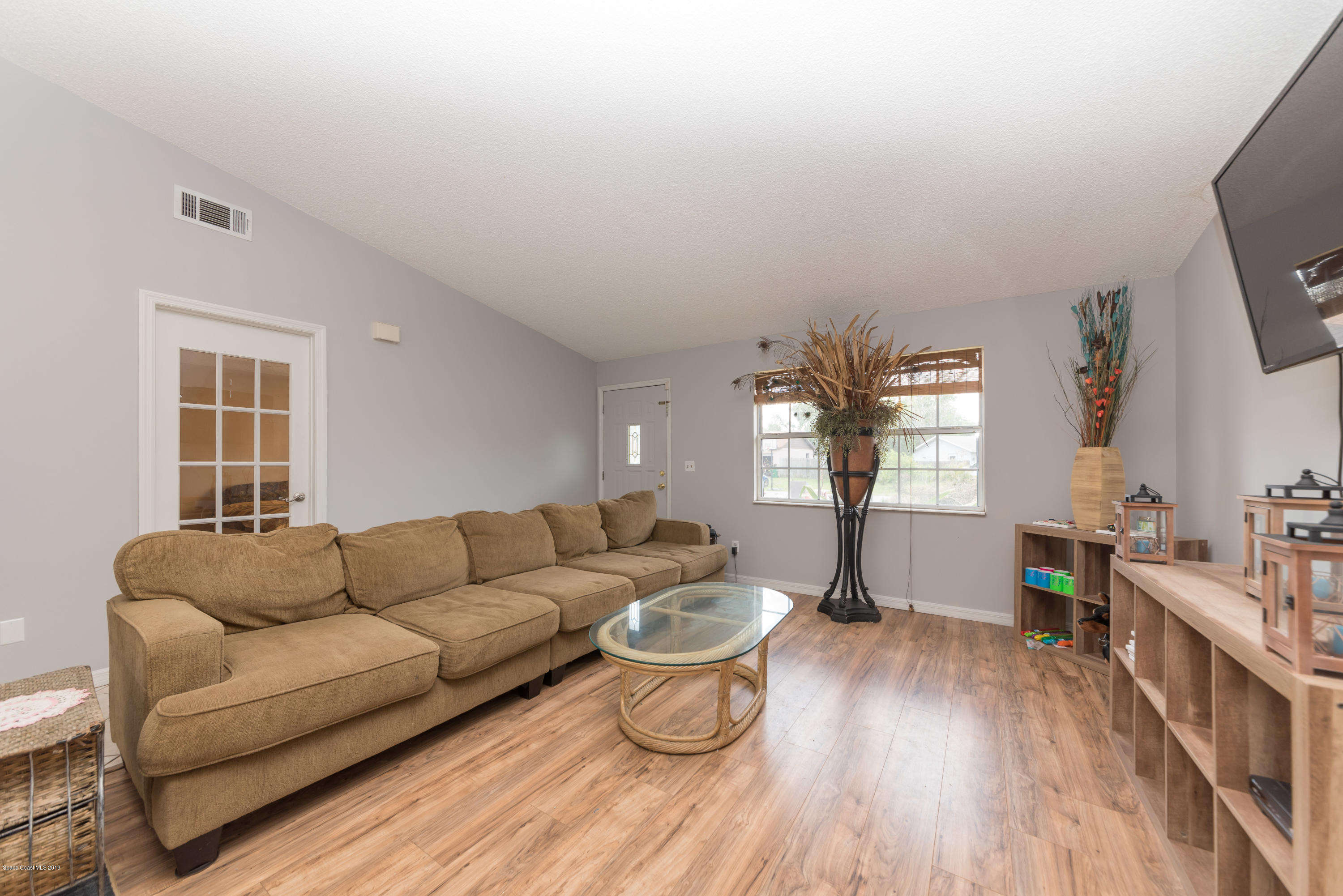 5660 Banos Avenue Cocoa, FL 32927 - Photo 13 of 22 a living room with furniture a fireplace and a flat screen tv