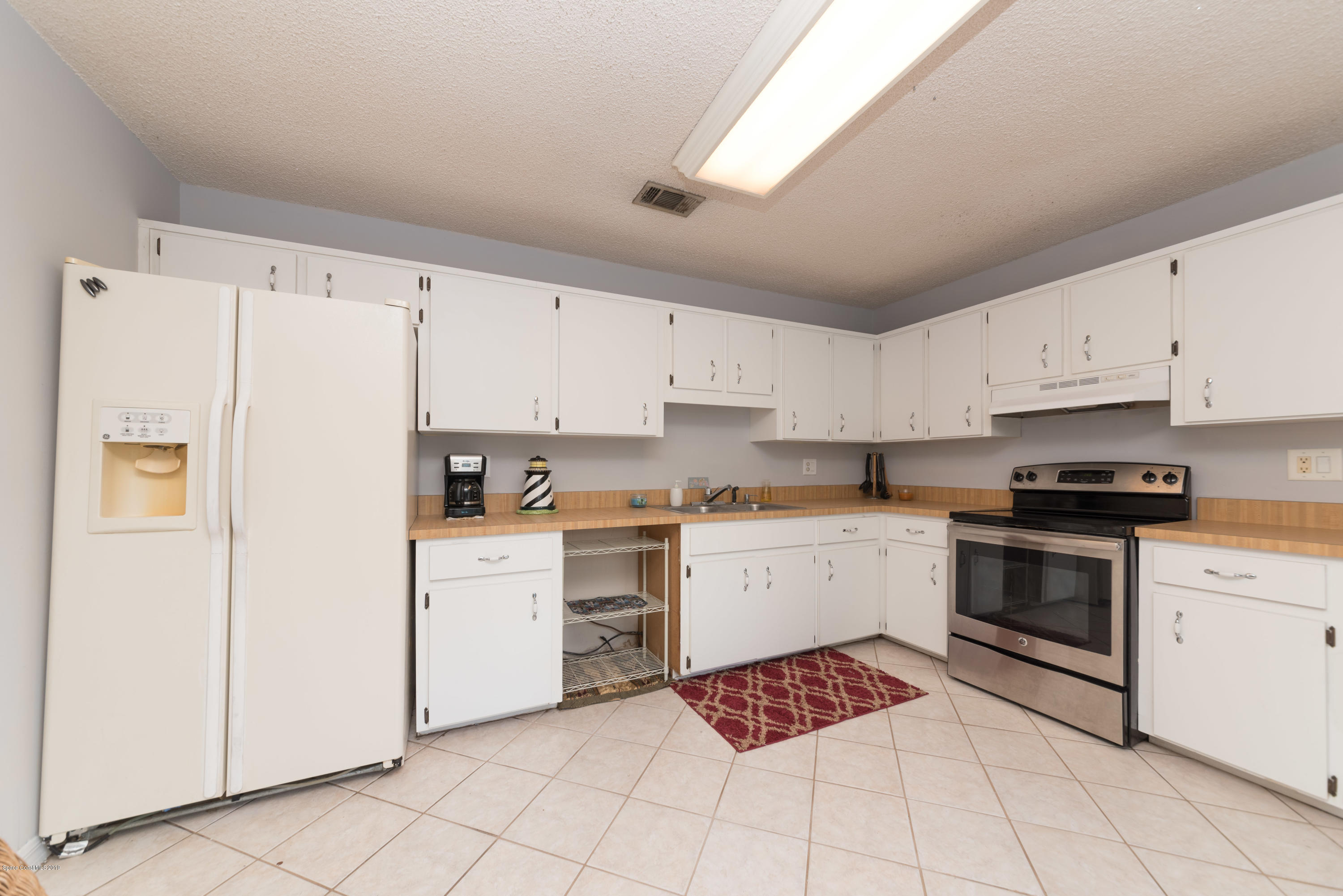 5660 Banos Avenue Cocoa, FL 32927 - Photo 16 of 22 a kitchen with cabinets stainless steel appliances and sink