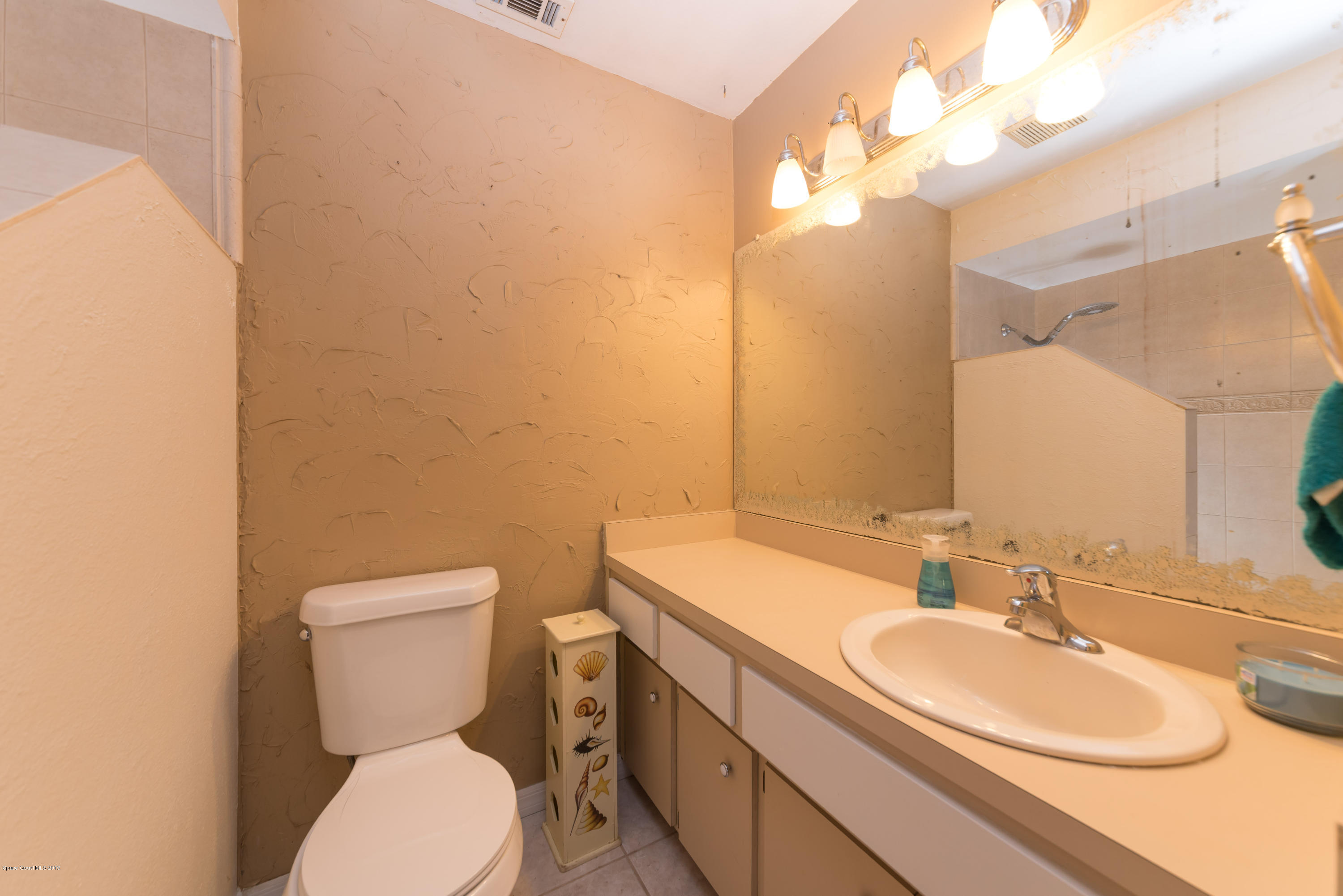 5660 Banos Avenue Cocoa, FL 32927 - Photo 18 of 22 a bathroom with a sink mirror vanity and toilet