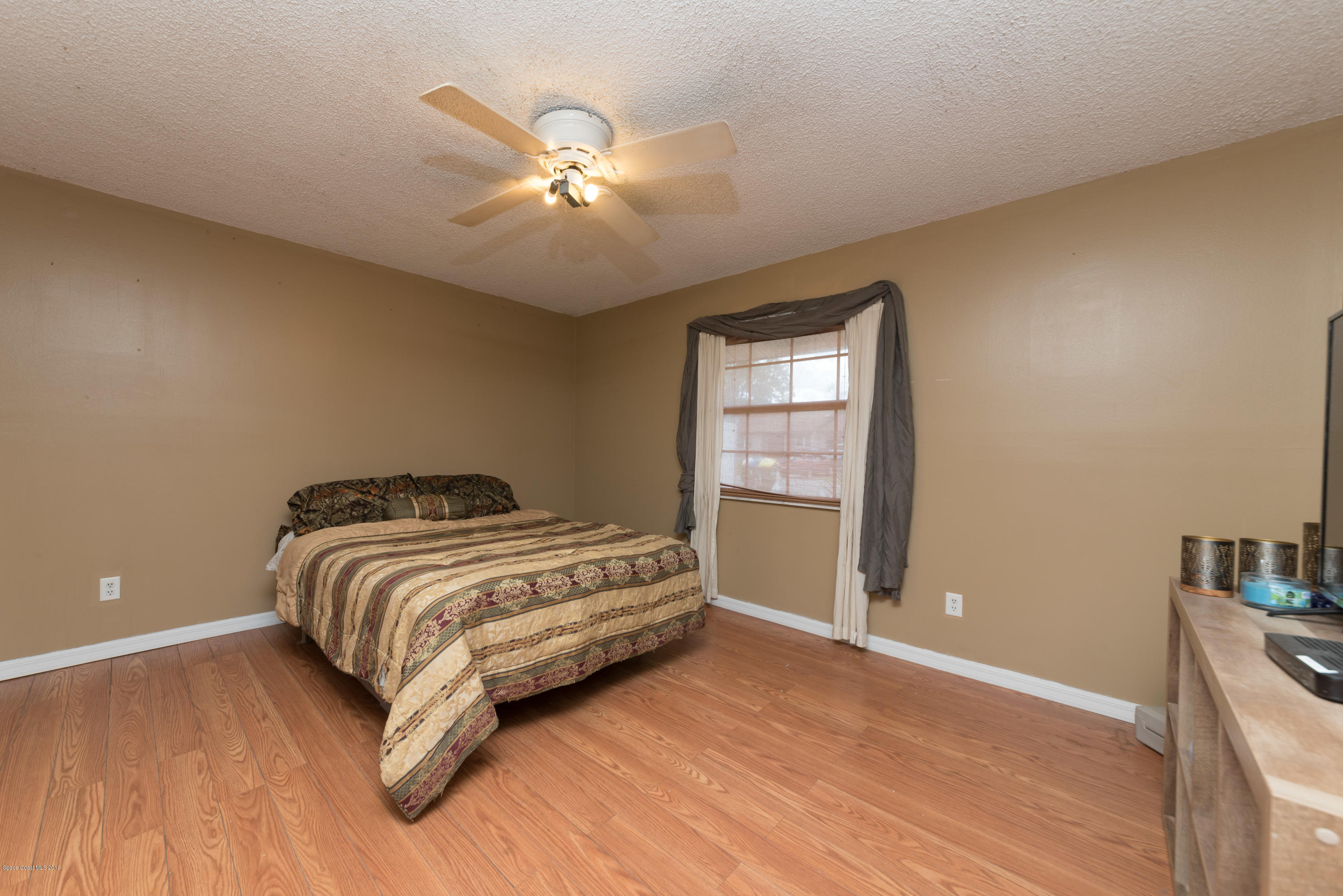 5660 Banos Avenue Cocoa, FL 32927 - Photo 19 of 22 a bedroom with a bed and a chandelier