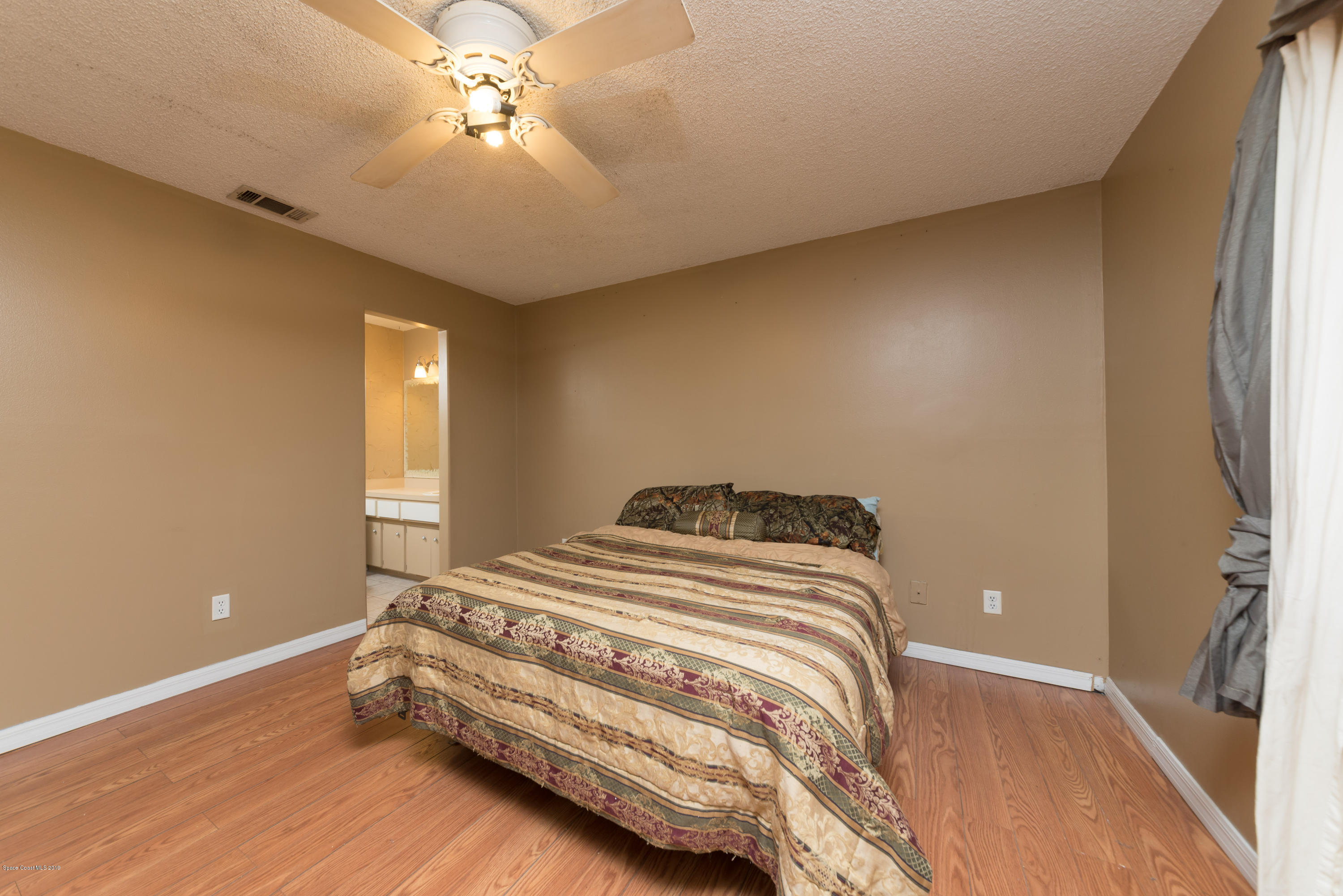 5660 Banos Avenue Cocoa, FL 32927 - Photo 20 of 22 a bedroom with a bed and a chandelier