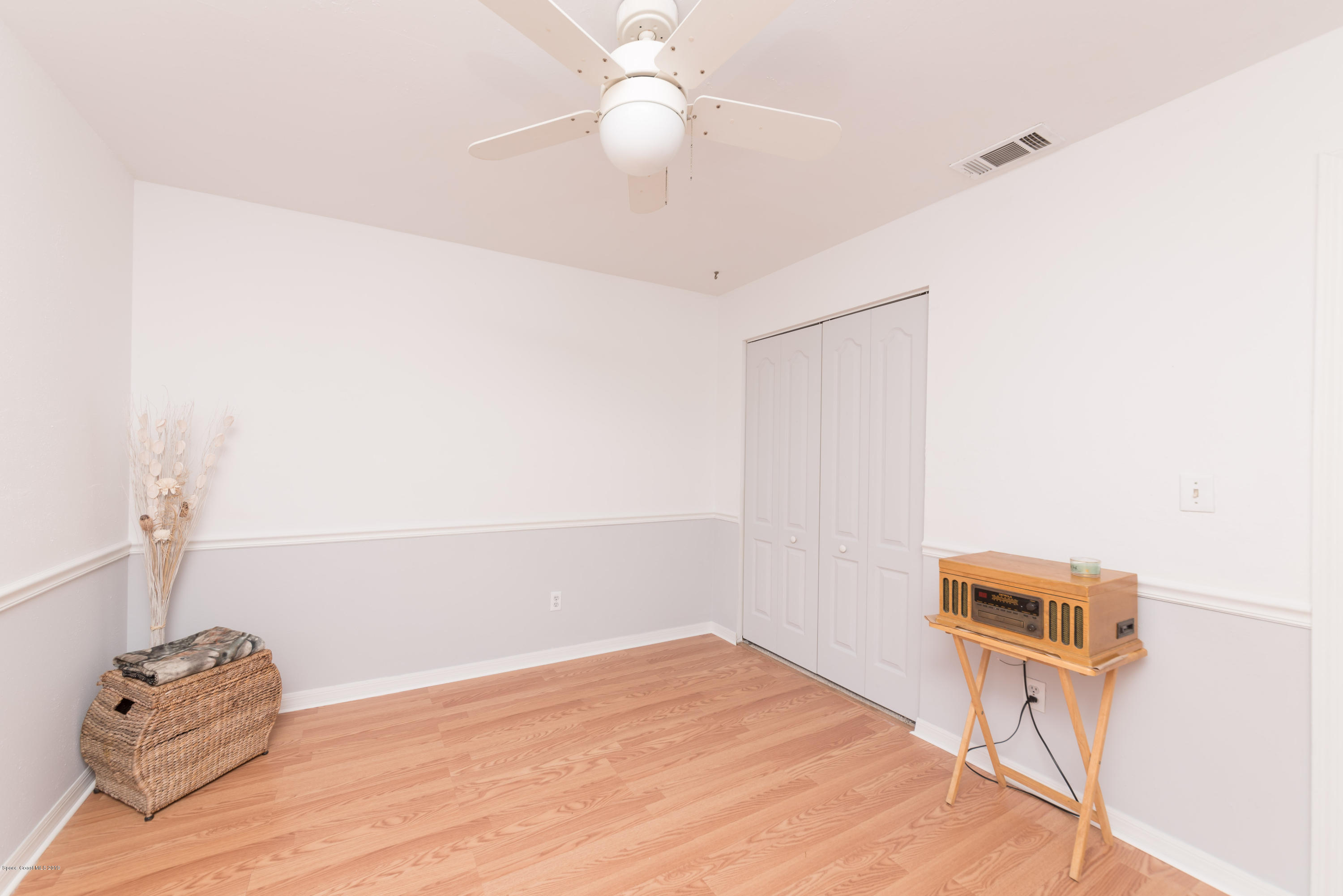 5660 Banos Avenue Cocoa, FL 32927 - Photo 7 of 22 a view of a room with wooden floor and ceiling fan