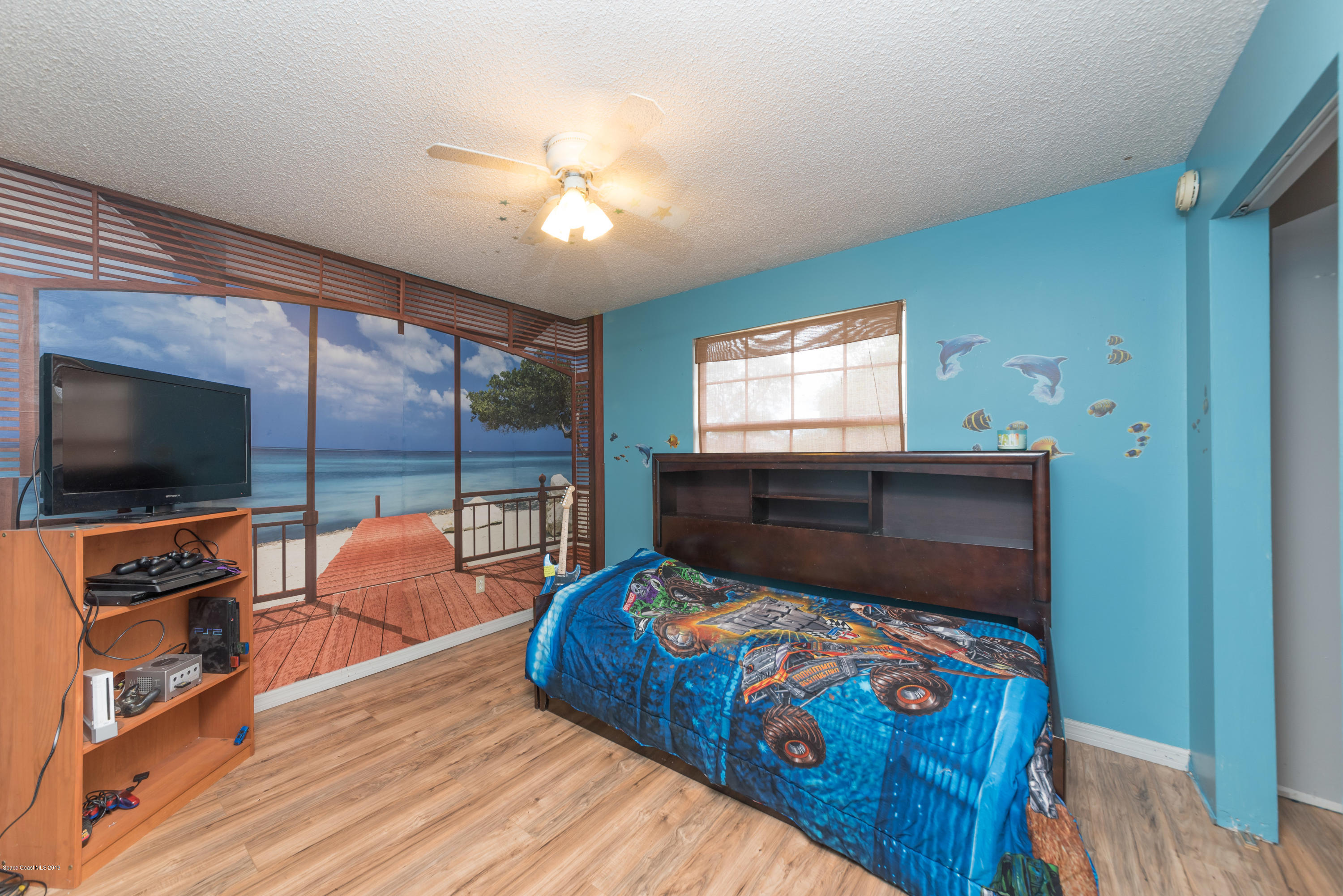 5660 Banos Avenue Cocoa, FL 32927 - Photo 8 of 22 a bedroom with a bed and flat tv screen on the dresser