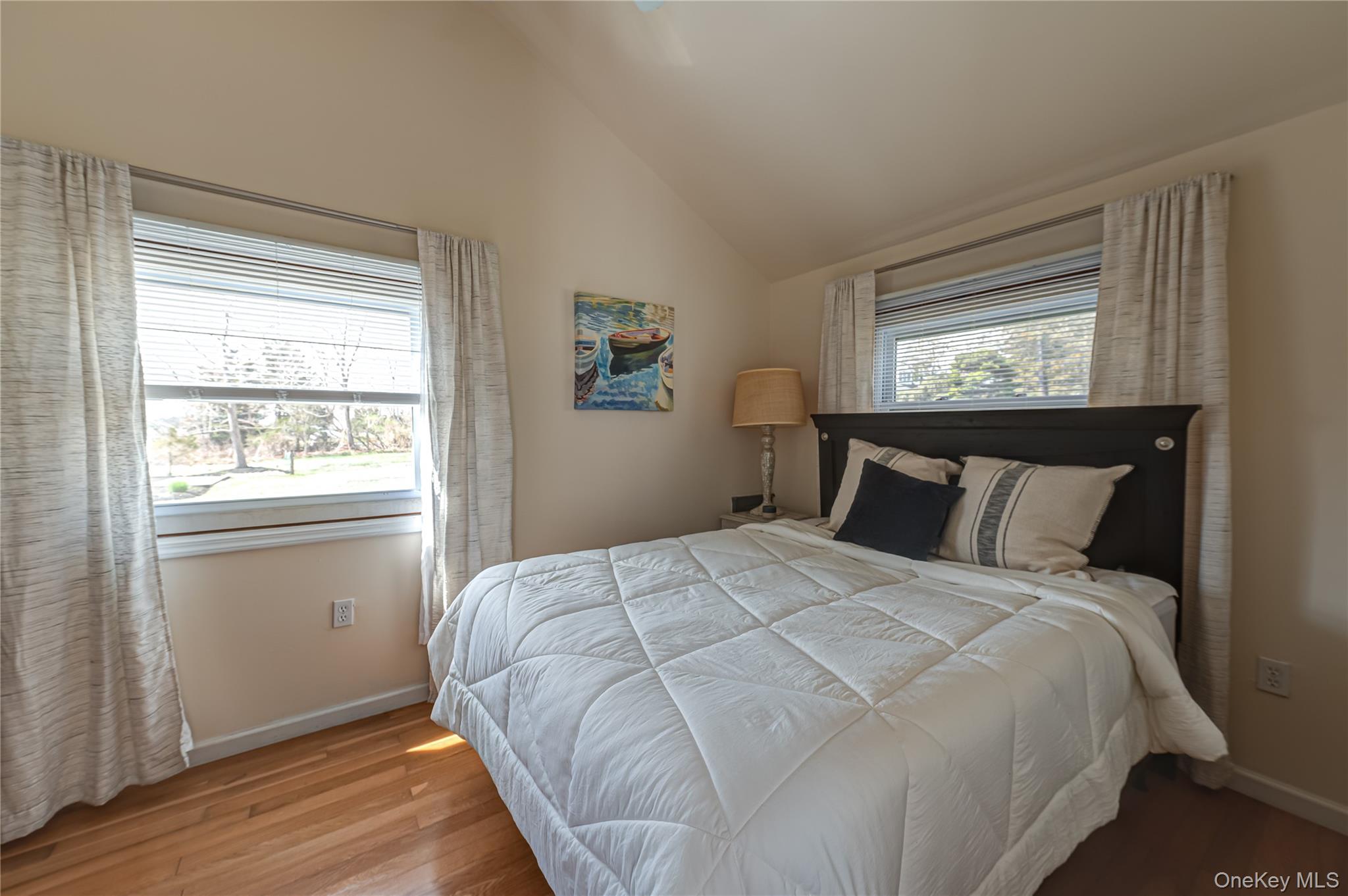 18 Shinnecock Road, Unit 2 Hampton Bays, NY 11946 - Photo 7 of 7 a large bed sitting in a bedroom next to a window