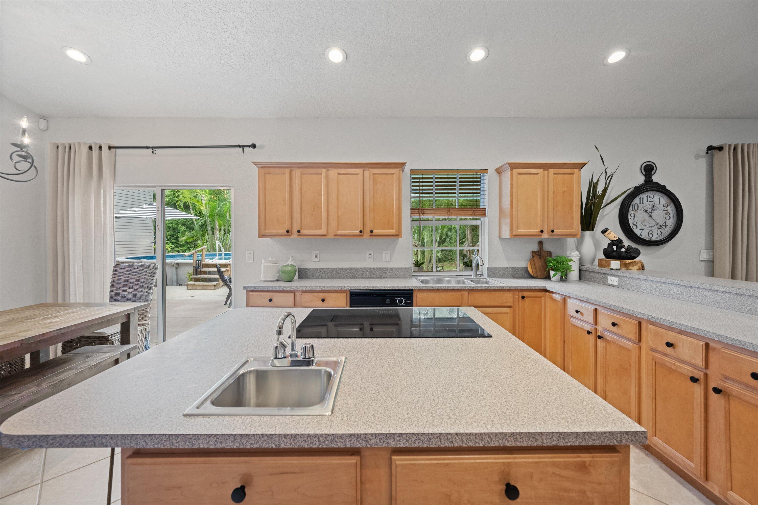 10771 154th Road North Jupiter, FL 33478 - Photo 20 of 87 a kitchen with granite countertop a sink a counter top space and cabinets