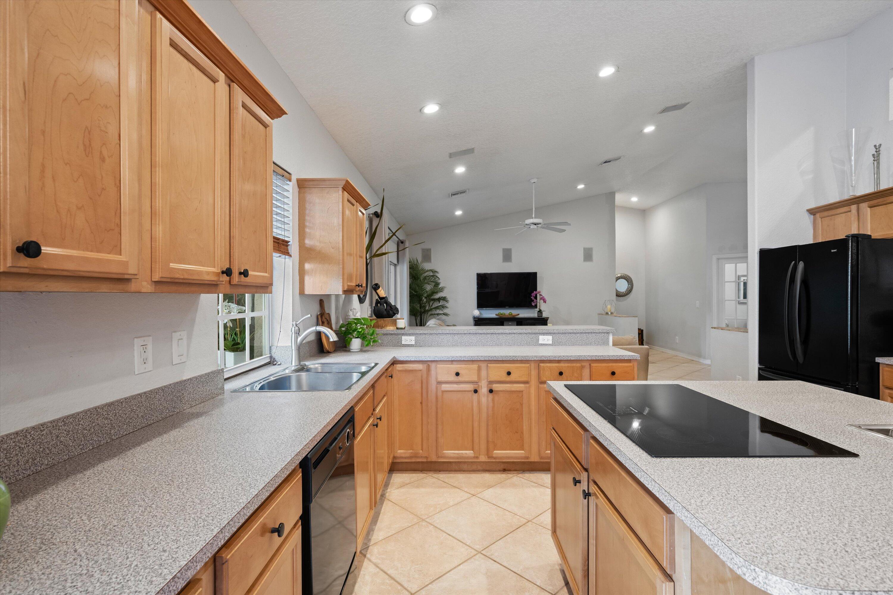 10771 154th Road North Jupiter, FL 33478 - Photo 22 of 87 a kitchen with a sink a counter top space cabinets and stainless steel appliances