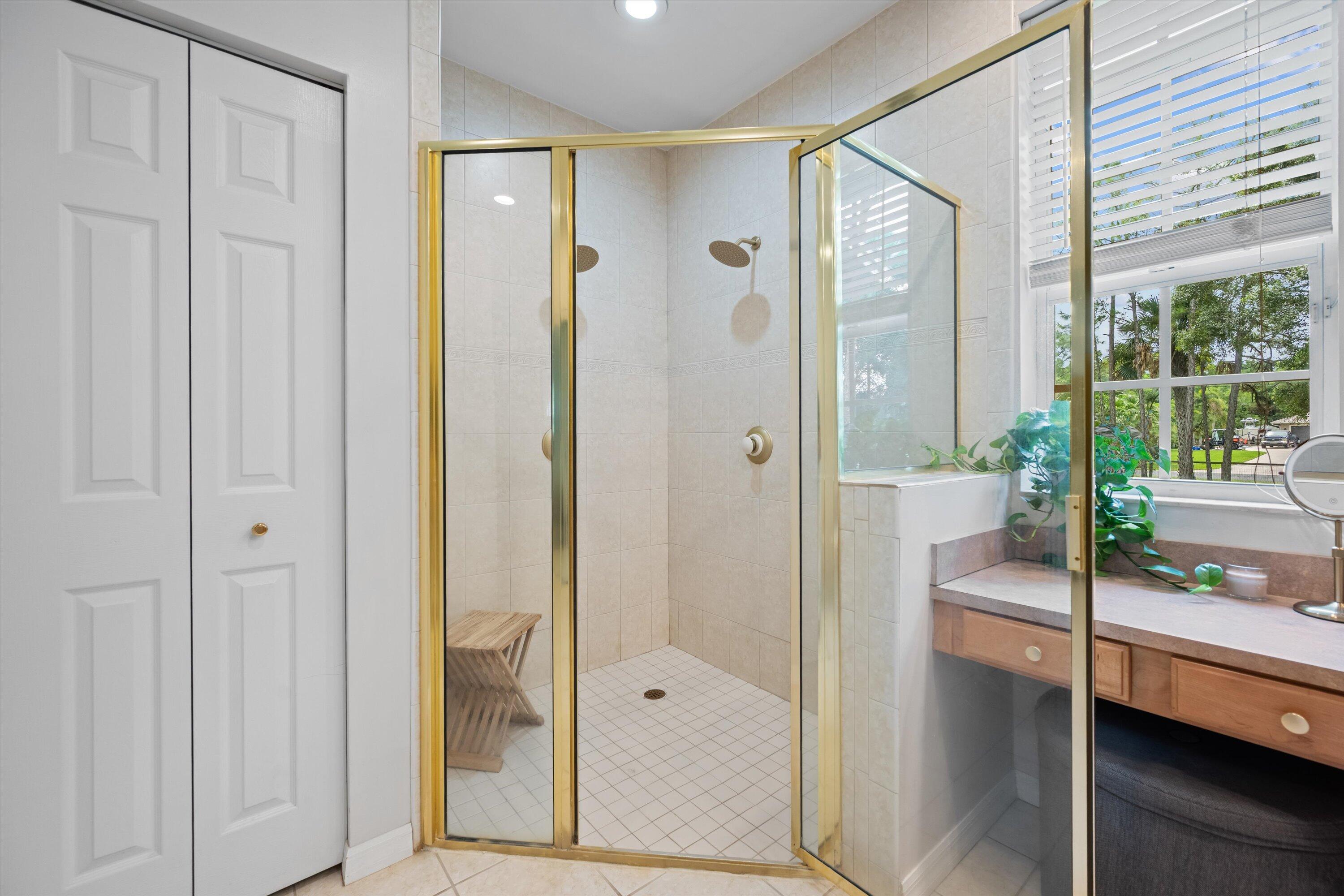 10771 154th Road North Jupiter, FL 33478 - Photo 39 of 87 a bathroom with a glass shower door and a glass door
