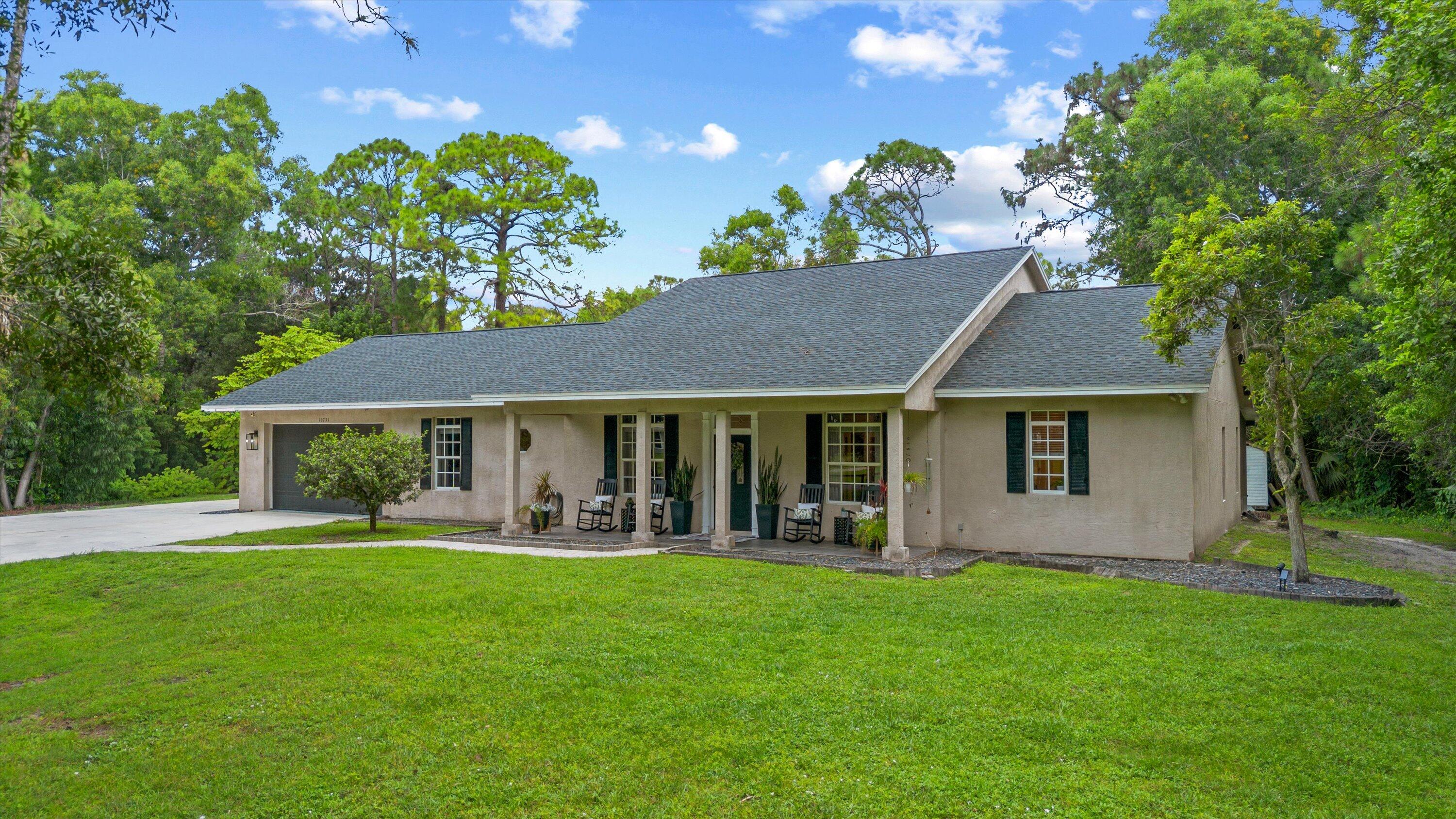 10771 154th Road North Jupiter, FL 33478 - Photo 4 of 87 a view of a house with a yard and potted plants