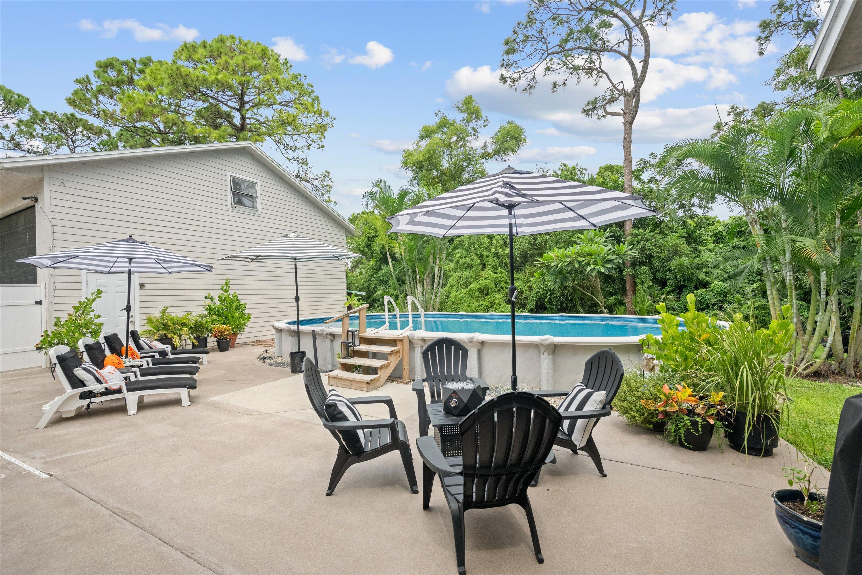 10771 154th Road North Jupiter, FL 33478 - Photo 56 of 87 a view of a patio with a table and chairs under an umbrella