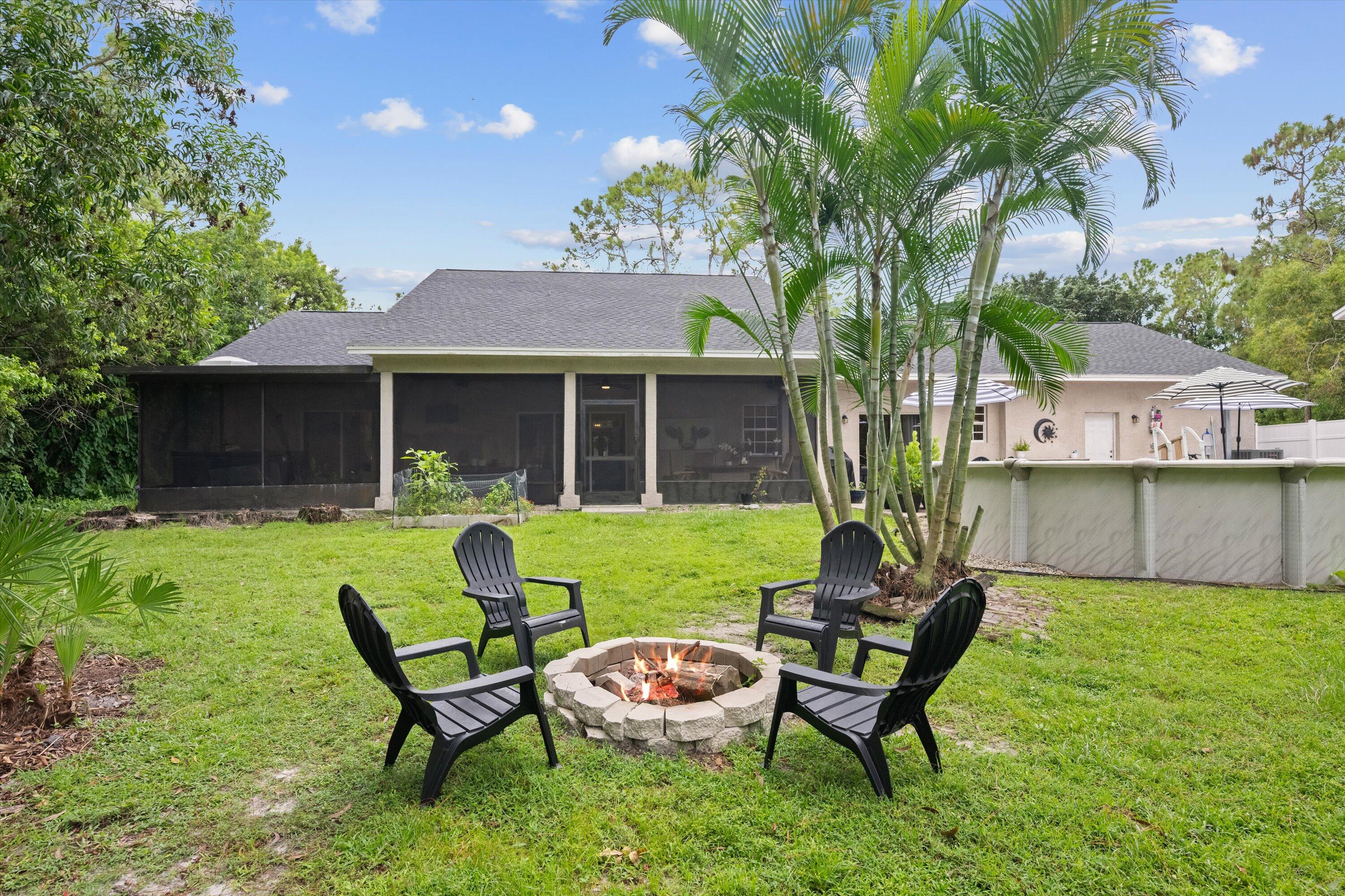 10771 154th Road North Jupiter, FL 33478 - Photo 66 of 87 a backyard of a house with table and chairs