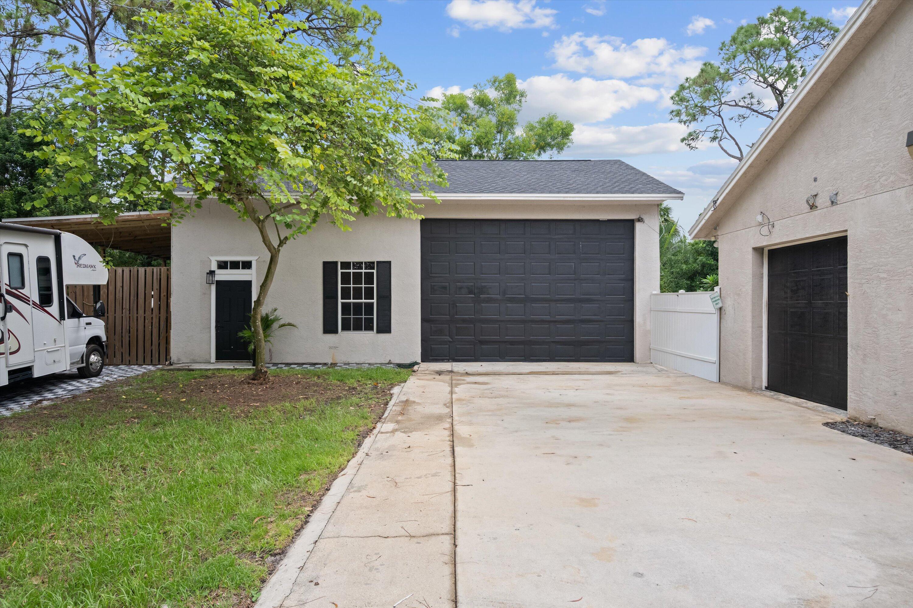 10771 154th Road North Jupiter, FL 33478 - Photo 7 of 87 a front view of a house with a yard and garage