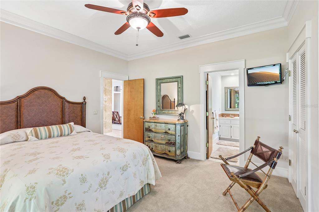 17810 Crawley Road Odessa, FL 33556 - Photo 26 of 76 a bedroom with a bed a chair and potted plant on the dresser