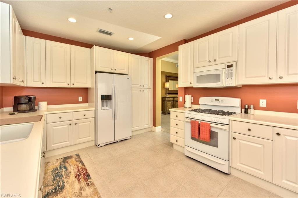 Undisclosed Address Naples, FL 34114 - Photo 6 of 25 a kitchen with white cabinets and white appliances