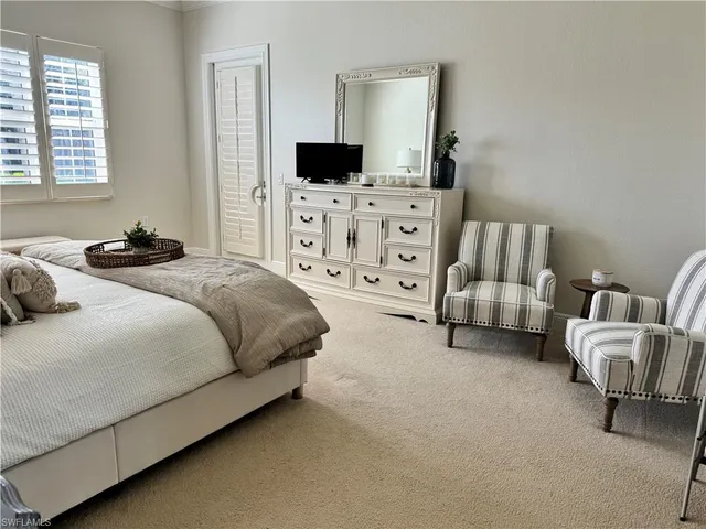 a spacious bedroom with a bed and a television