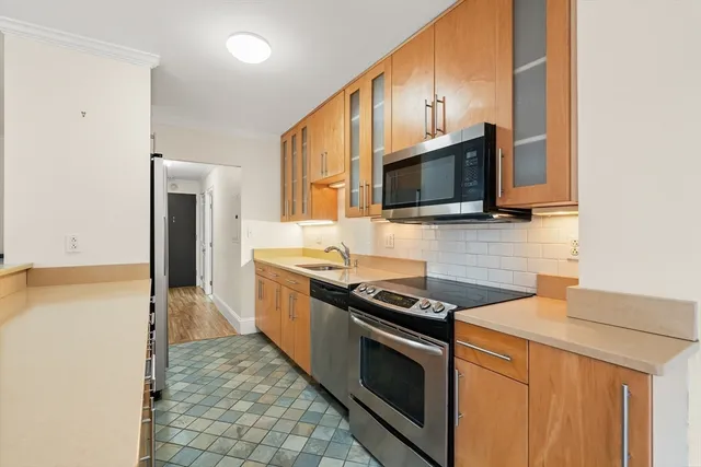 a kitchen with stainless steel appliances a stove microwave and refrigerator