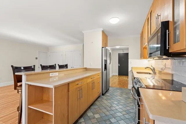 a view of a kitchen with stainless steel appliances granite countertop a stove and a refrigerator