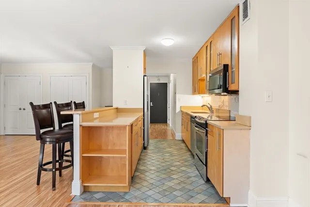 a kitchen with kitchen island granite countertop wooden floors and stainless steel appliances