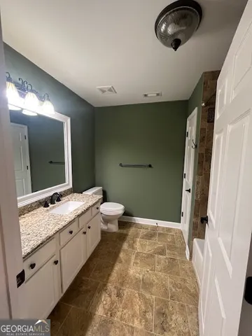 a bathroom with a double vanity sink toilet and mirror