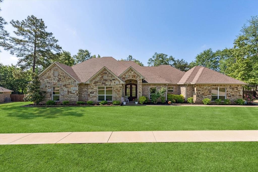a view of a big house with a big yard and large trees