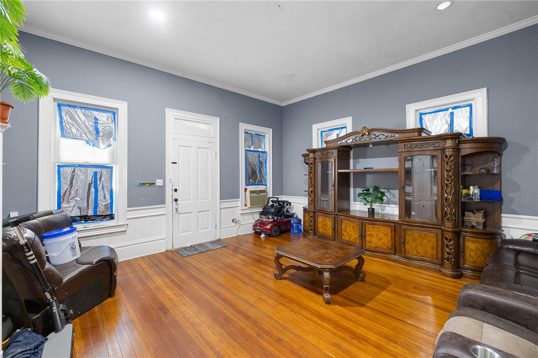 610 West Davis Street Hearne, TX 77859 - Photo 11 of 27 Living area featuring ornamental molding, wood-type flooring, wainscoting, and a decorative wall