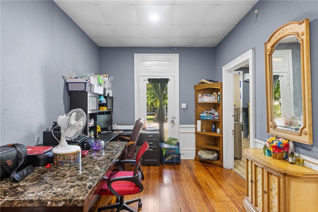 610 West Davis Street Hearne, TX 77859 - Photo 12 of 27 Home office featuring wainscoting, hardwood / wood-style flooring, and a drop ceiling