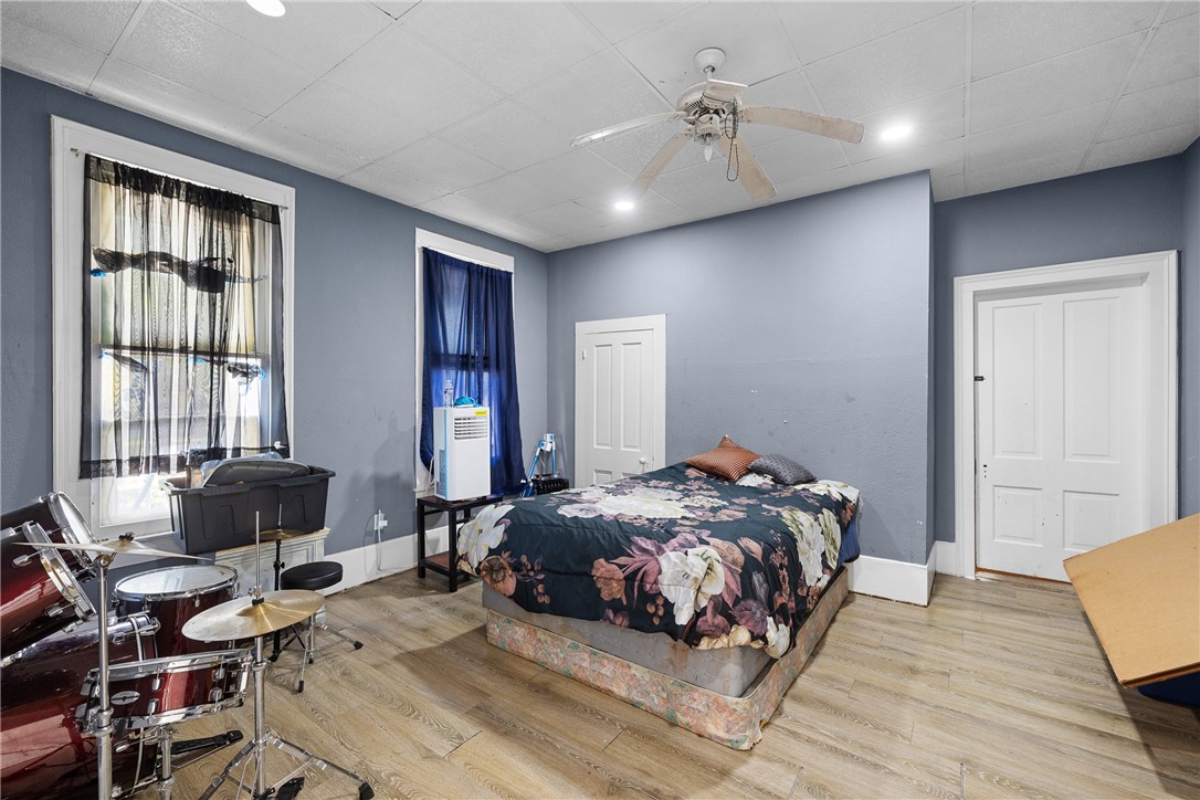 610 West Davis Street Hearne, TX 77859 - Photo 19 of 27 Bedroom featuring light wood-type flooring, a ceiling fan, and a paneled ceiling
