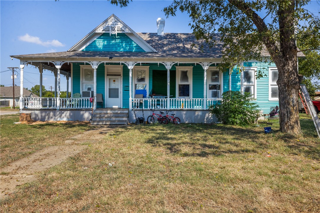 610 West Davis Street Hearne, TX 77859 - Photo 2 of 27 View of front of home featuring a porch, a front yard, and a chimney